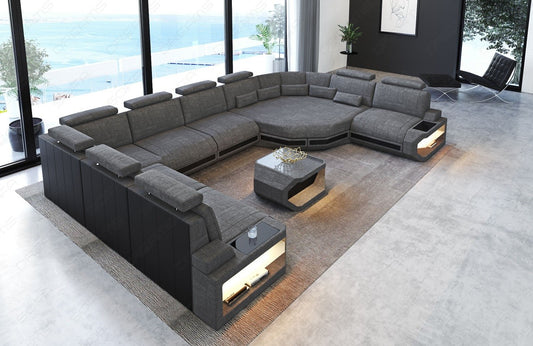 Stoff Wohnlandschaft Asti U Form in grau - Hugo5 mit der Nebenfarbe Schwarz. Couchtisch und USB-Anschlüsse sind optional erhältlich.